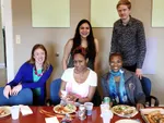 5 people in front of a table with lunch food.