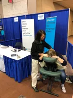 Photo of the Collaborate booth with someone getting a massage from March 2018.